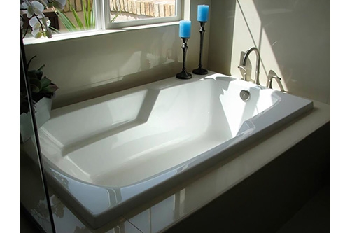 white solo beauty tub with blue candles next to it